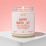 A white candle with a lit flame, labeled as a birthday candle, against a pink background.