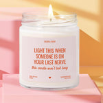 a white candle with a flame, placed on a pink surface against a yellow background.