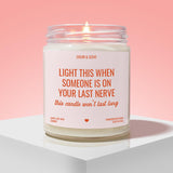 a white candle with a pink background, placed on a white surface. The candle has a label that reads "Light this when someone is on your last nerve" and "this candle won't last long".